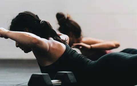 Personal trainer running a single one-to-one session with a client in a bright Phuket studio