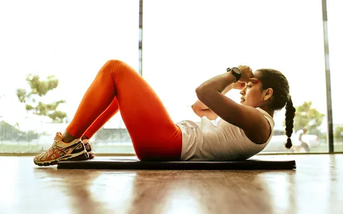 Woman training on a mat in a bright Phuket studio, illustrating the personal trainer cost in Phuket