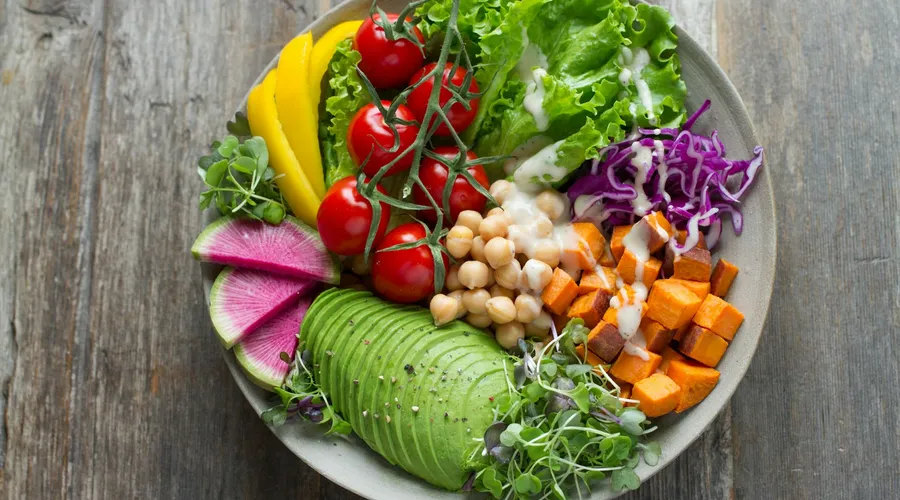 Colourful balanced bowl of vegetables, chickpeas and avocado, illustrating a healthy diet plan for women