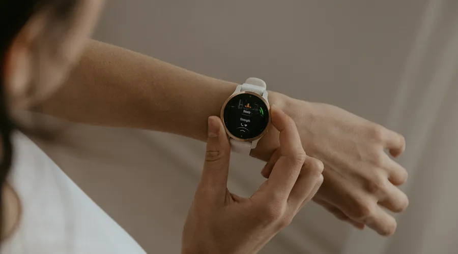 Woman checking her fitness watch to plan how often to train with a personal trainer