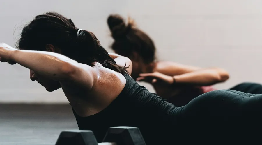 Personal trainer running a single one-to-one session with a client in a bright Phuket studio