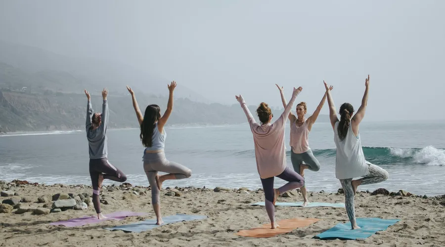 Women doing beach yoga on holiday in Phuket
