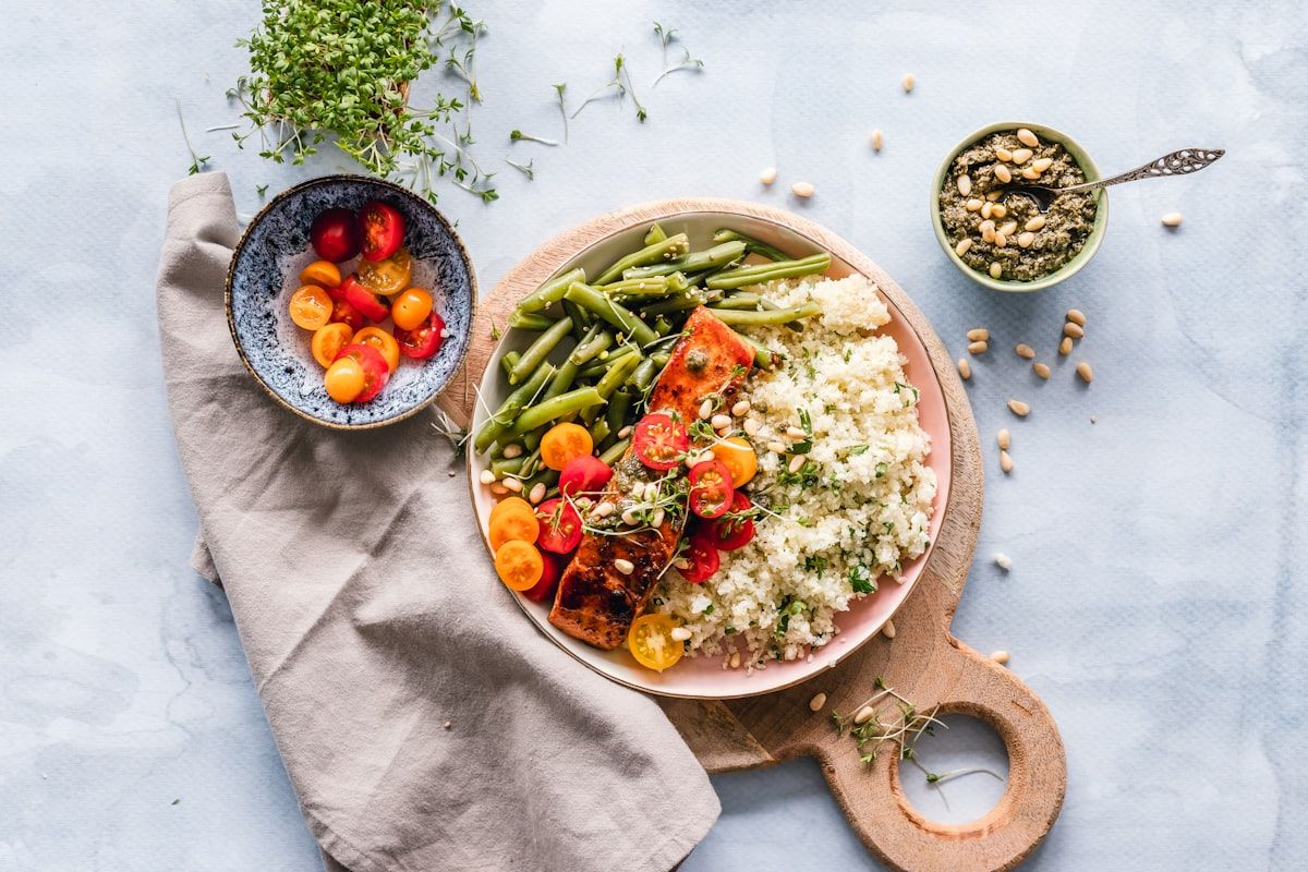 A balanced high-protein whole-food plate with vegetables and grains, the basis of a trainer's nutrition coaching