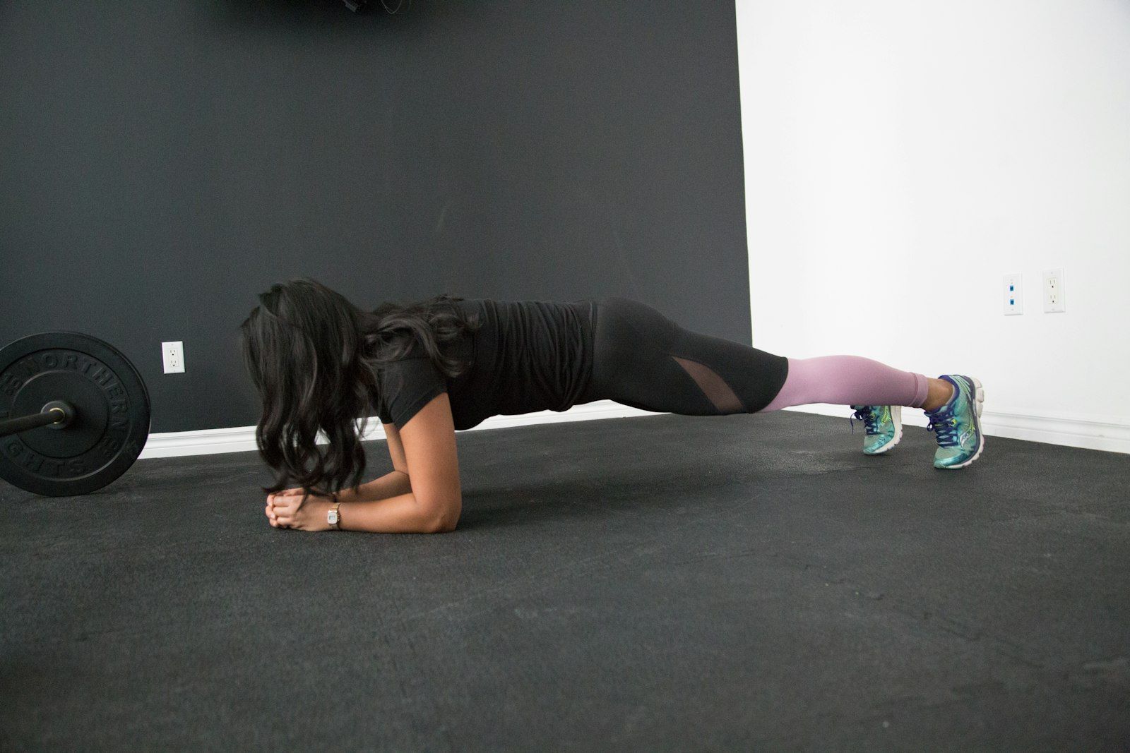 Woman holding a plank in a bright studio, building strength and confidence with a female trainer