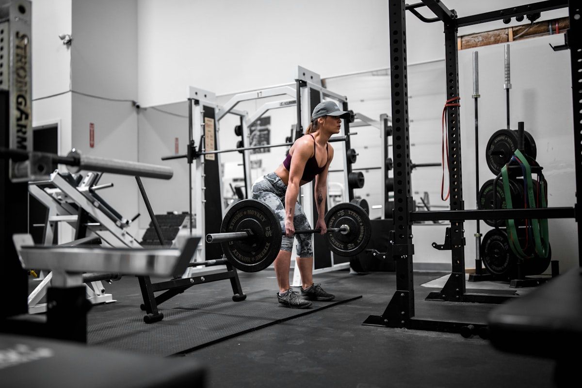 Woman training with dumbbells under a trainer's guidance in a bright Rawai studio