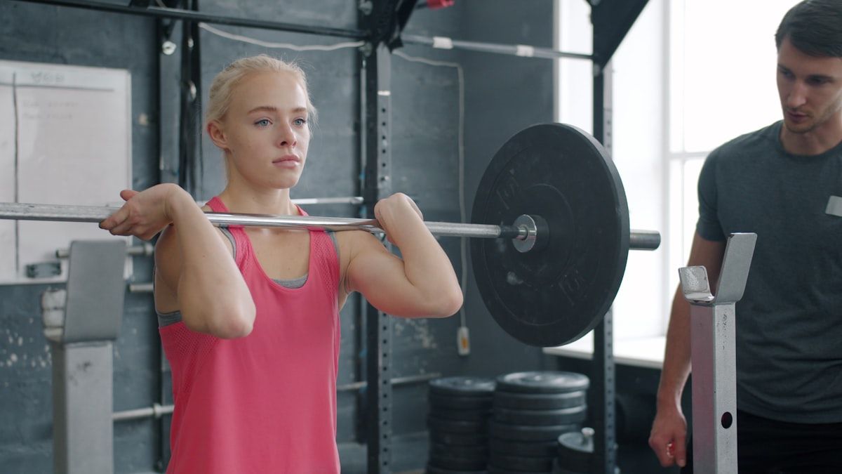 A personal trainer coaching a client through a set, the accountability that drives weight loss